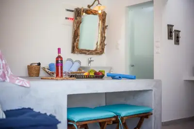 a kitchen counter with two stools and a mirror at Len Art Alternative Studios in Faliraki