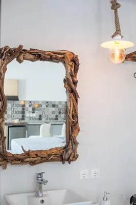 a mirror on a wall above a sink in a bathroom at Len Art Alternative Studios in Faliraki