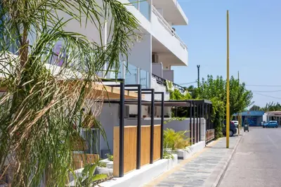 a facade of a building with a fence at Len Art Alternative Studios in Faliraki