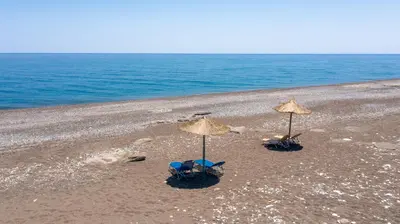 two chairs and two umbrellas on a beach at Gennadi Serenity House- beachfront villa with pool in Gennadi