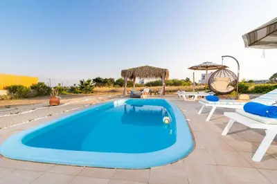 a large blue swimming pool on a patio at Gennadi Serenity House- beachfront villa with pool in Gennadi