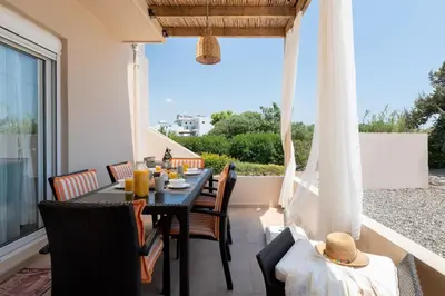 a dining table on the balcony of a house at Gennadi Serenity House- beachfront villa with pool in Gennadi