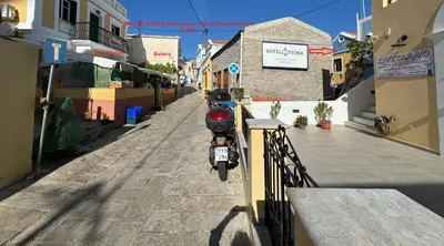 a motorcycle parked on the side of a street at Hotel Fiona Symi in Symi