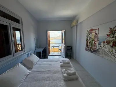 a bedroom with a bed with two pillows on it at Hotel Fiona Symi in Symi