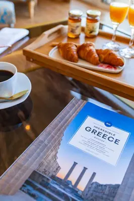 a table with a plate of croissants and a cup of coffee at FlyViewFlatsGOLD PrivateHotTub with SeaView in Rhodes Town