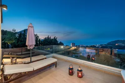 a balcony with an umbrella and two scooters at FlyViewFlatsGOLD PrivateHotTub with SeaView in Rhodes Town