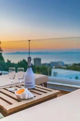 a bottle of wine and two glasses on a table at FlyViewFlatsGOLD PrivateHotTub with SeaView in Rhodes Town