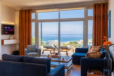 a living room with a view of the ocean at FlyViewFlatsGOLD PrivateHotTub with SeaView in Rhodes Town