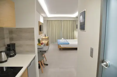 a kitchen and a bedroom with a bed in a room at Emerald Hotel in Kremasti