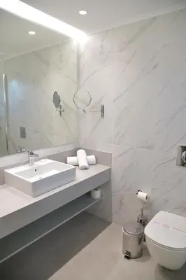 a bathroom with a sink and a toilet and a mirror at Emerald Hotel in Kremasti