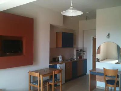 a kitchen with a table and a dining room at Emerald Hotel in Kremasti