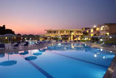a large swimming pool at a resort at night at Emerald Hotel in Kremasti