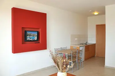 a living room with a red wall and a table at Emerald Hotel in Kremasti