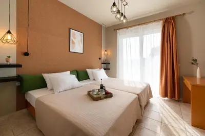 a hotel room with two beds and a window at GOJI Vegan Hotel in Ialyssos