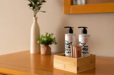 a wooden holder with two hair products on a table at GOJI Vegan Hotel in Ialyssos