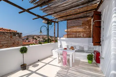 a balcony with a table on a white wall at Atlantis Houses in Halki