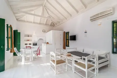 a white living room with a table and chairs at Atlantis Houses in Halki
