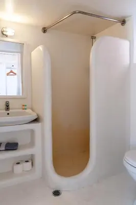 a white bathroom with a sink and a mirror at Atlantis Houses in Halki