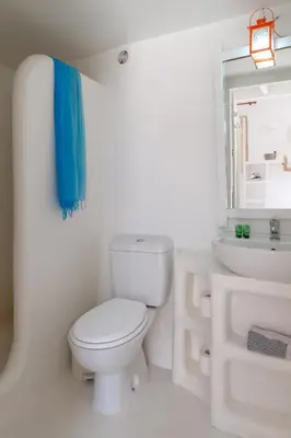 a white bathroom with a toilet and a sink at Atlantis Houses in Halki
