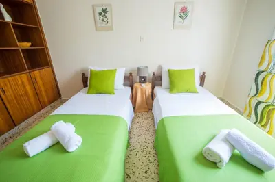two beds in a room with green and white sheets at Country House in Pastida