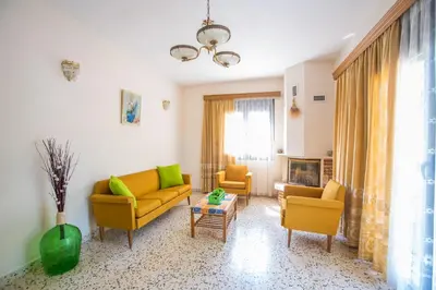 a living room with yellow couches and a fireplace at Country House in Pastida