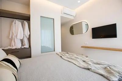 a bedroom with a bed and a tv on the wall at Muses of art Villas in Afantou