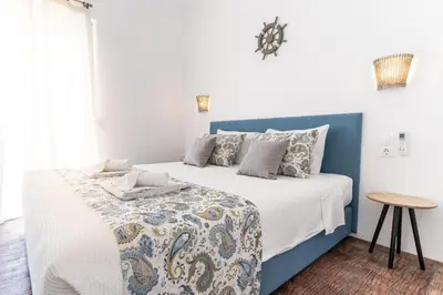 a blue and white bed in a room with a table at Muses of art Villas in Afantou