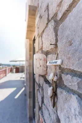 a stone wall with a sign that says imagine on it at Muses of art Villas in Afantou