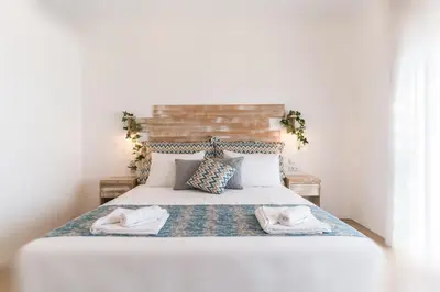 a bedroom with a large white bed with towels on it at Muses of art Villas in Afantou