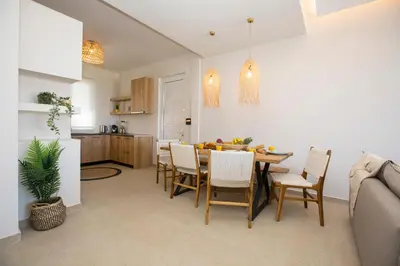 a kitchen and dining room with a table and chairs at Muses of art Villas in Afantou