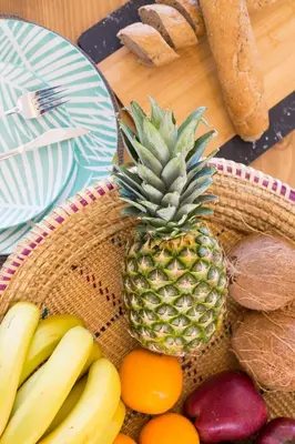 a pineapple in a basket of fruit on a table at Muses of art Villas in Afantou