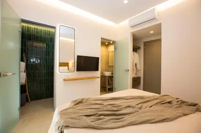 a bedroom with a bed and a shower and a television at Muses of art Villas in Afantou