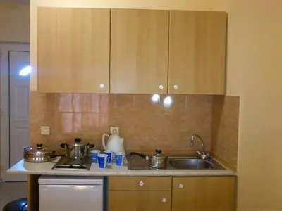 a kitchen with wooden cabinets and a sink at Summer Memories Aparthotel in Pefki Rhodes