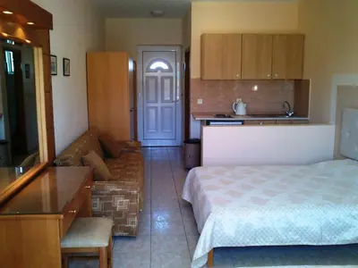a bedroom with a bed and a couch and a kitchen at Summer Memories Aparthotel in Pefki Rhodes