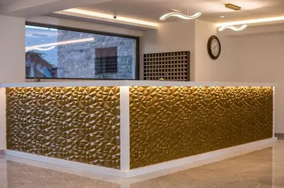 a gold accent wall in a room with a clock at Lardos Bay Hotel in Lardos