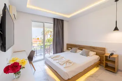a bedroom with a bed and a balcony at Lardos Bay Hotel in Lardos