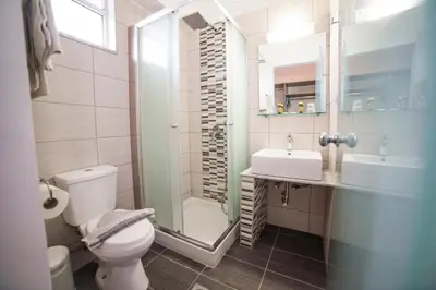 a bathroom with a toilet and a sink and a shower at Lardos Bay Hotel in Lardos