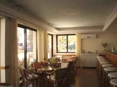 a dining room with tables and chairs and windows at Nafsika Hotel in Rhodes Town