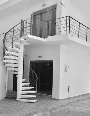 a spiral staircase on the side of a building at Melita Apartment Seaside in Haraki