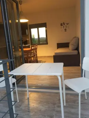 a living room with a white table and a couch at Melita Apartment Seaside in Haraki