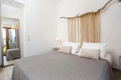 a white bedroom with a large bed with two pillows at Villa Kora in Kallithea Rhodes