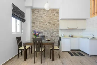 a kitchen and dining room with a table and chairs at Vlycha Beach Apartments in Líndos