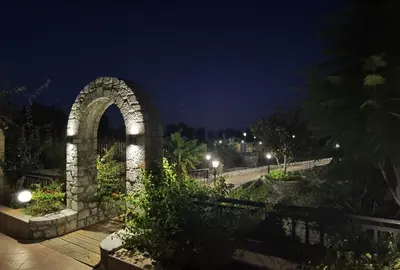 a stone archway in a park at night at Vlycha Beach Apartments in Líndos