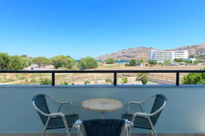 a balcony with a table and chairs and a view at Vlycha Beach Apartments in Líndos