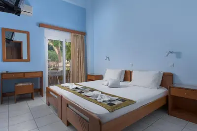 a bedroom with a bed with a mirror and a window at Vlycha Beach Apartments in Líndos