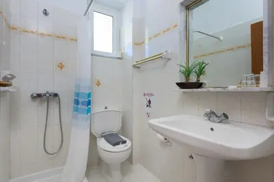 a bathroom with a toilet and a sink and a shower at Vlycha Beach Apartments in Líndos
