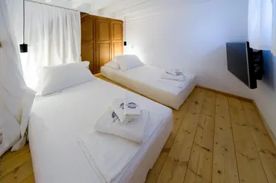 two beds in a small room with a television at Villa Myrto in Líndos