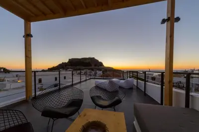 a balcony with a table and chairs and a view of the ocean at Villa Myrto in Líndos
