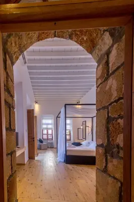 a large room with a bed and a brick wall at Villa Myrto in Líndos