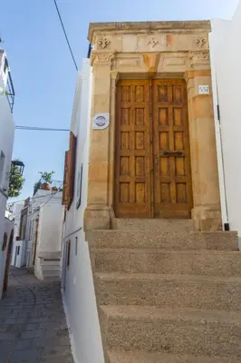 a wooden door on the side of a building with stairs at Villa Myrto in Líndos